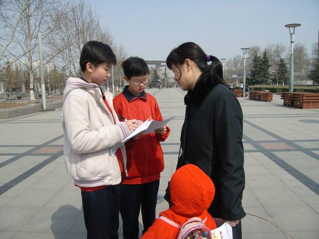 0915班同学正向路人进行关于低碳生活的调查问卷