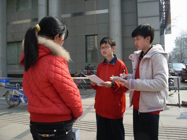 0915班同学正向路人进行关于低碳生活的调查问卷